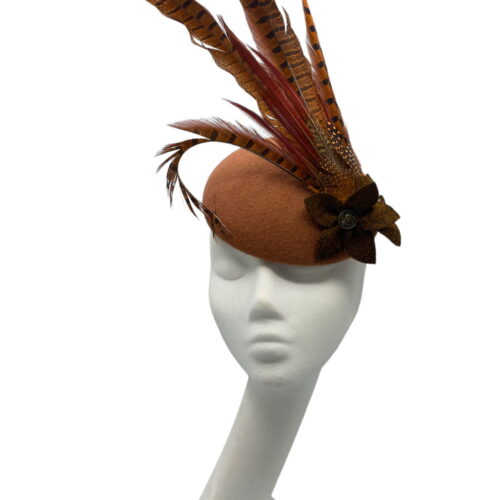 Copper coloured felt headpiece with an array of complementary feathers.